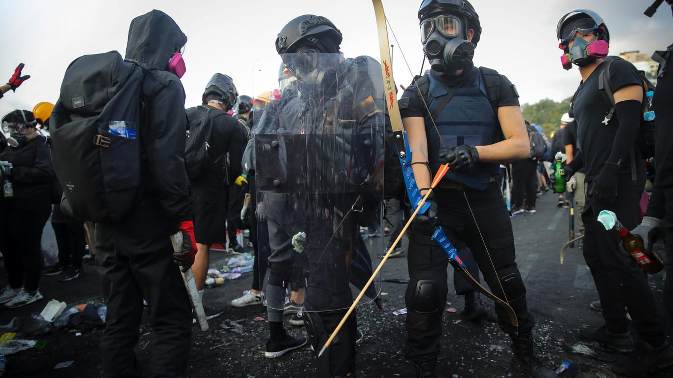 Bewaffnete Demonstranten stehen vor einer Universität: Nachdem erneut ein Student von einem Polizisten angeschossen wurde kommt es in Hongkong erneut zu chaotischen Szenen.