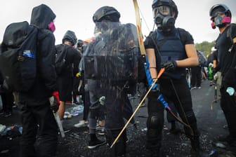 Bewaffnete Demonstranten stehen vor einer Universität: Nachdem erneut ein Student von einem Polizisten angeschossen wurde kommt es in Hongkong erneut zu chaotischen Szenen.