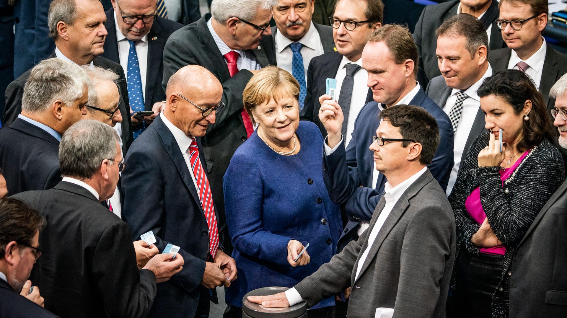 Bundeskanzlerin Angela Merkel (CDU) wirft bei der namentlichen Abstimmung zum Solidaritätszuschlag ihre Stimmkarte ein.