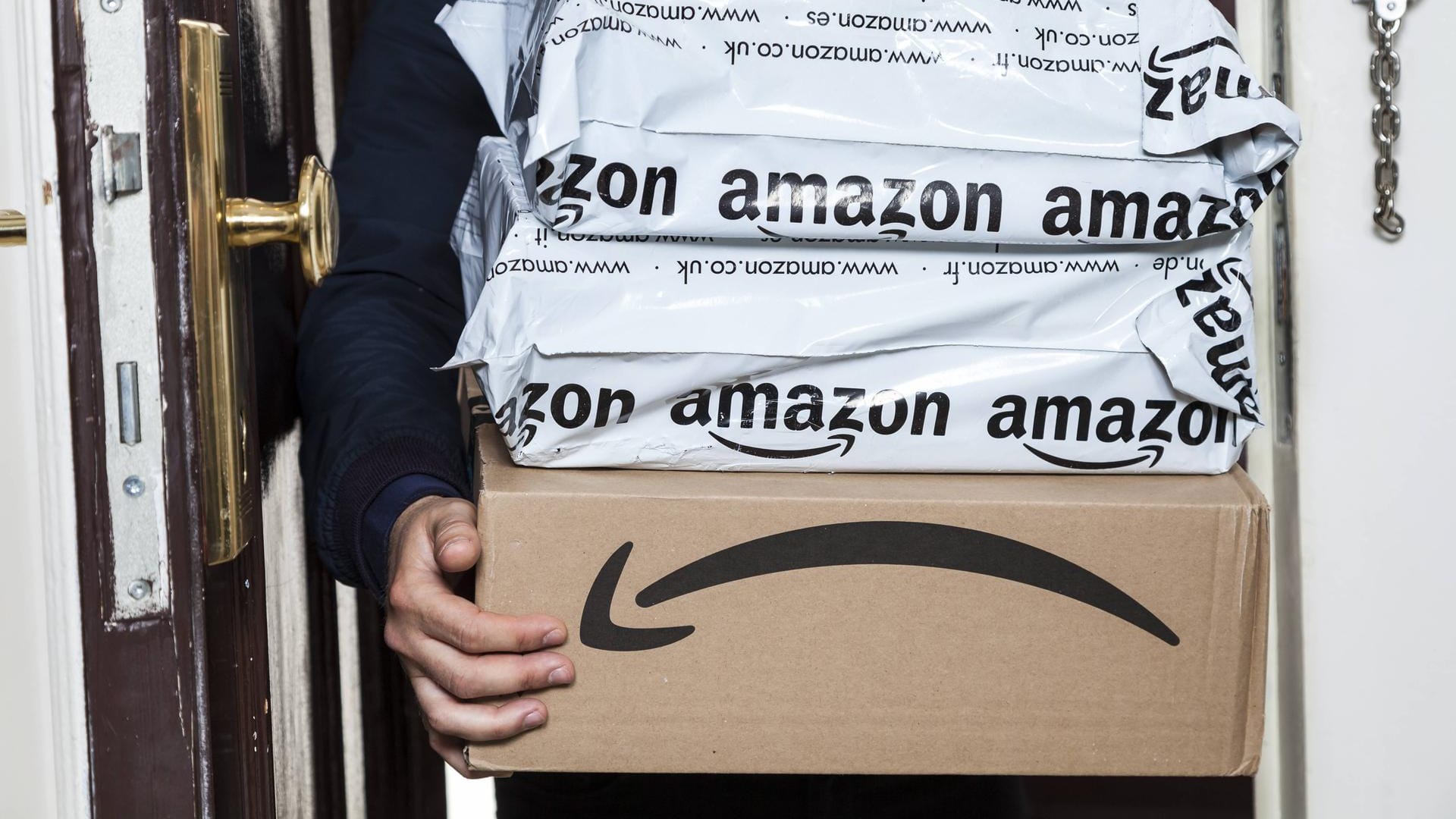 Mann hält mehrere Amazon Pakete: Amazon testet Sammellieferung in Deutschland.