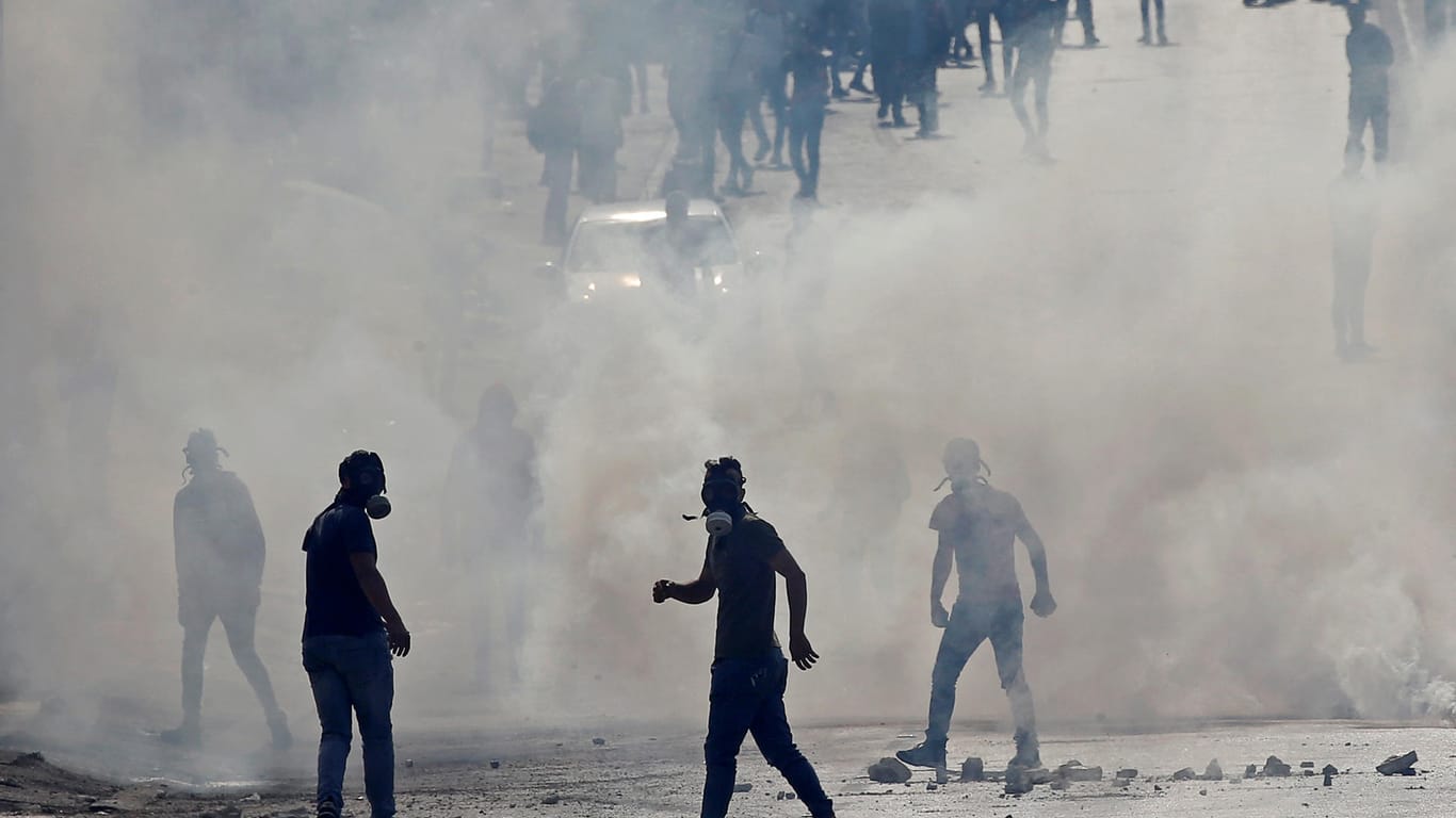 Palästinensische Demonstranten schützen sich mit Gasmasken gegen Tränengas.
