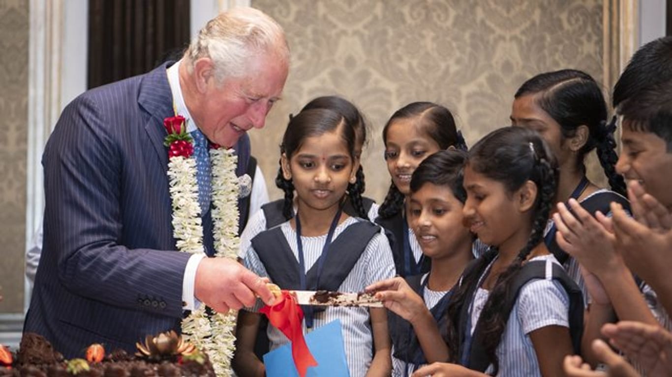 Der britische Prinz Charles schneidet seine Geburtstagstorte an.