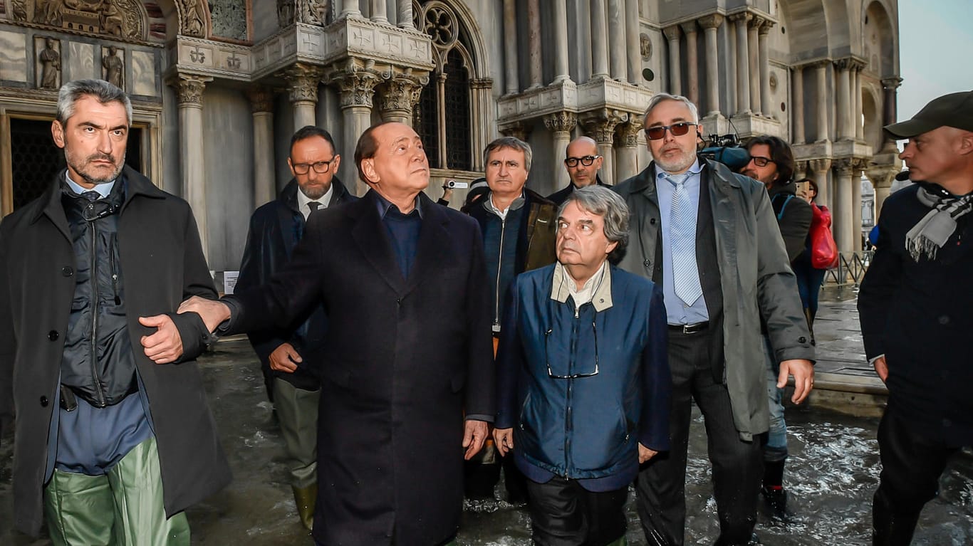 Silvio Berlusconi (M), ehemaliger Ministerpräsident von Italien und Forza Italia-Parteichef, geht in Gummistiefeln mit Luigi Brugnaro (2. Reihe,M), Bürgermeister von Venedig, und Renato Brunetta (3.v.r), Leiter der Abgeordnetengruppe von Forza Italia, bei Hochwasser über den Markusplatz.