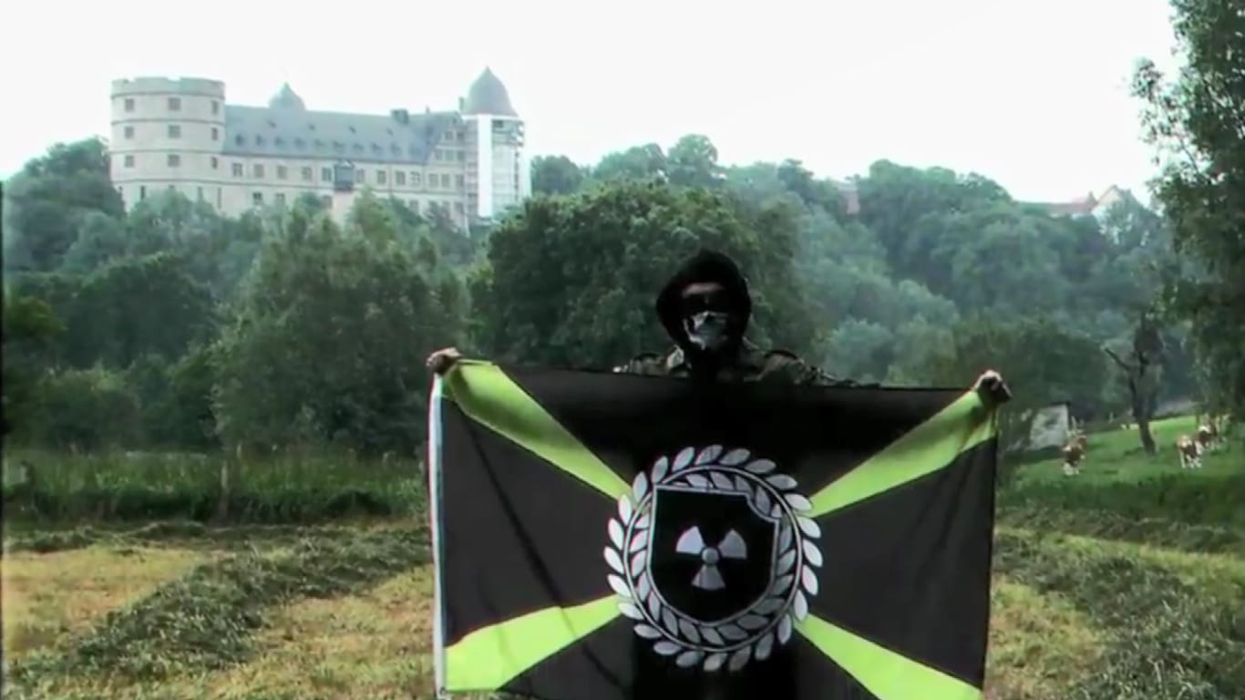 Neonazi mit Flagge der Atomwaffen Division im einzigen Video der deutschen Organisation vor der Wewelsburg.