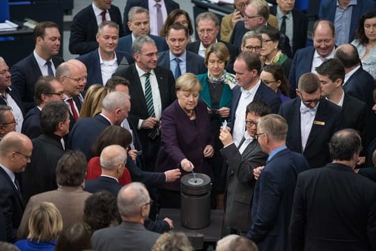 Bundeskanzlerin Angela Merkel (CDU) und weitere Abgeordnete stimmen bei der 128.