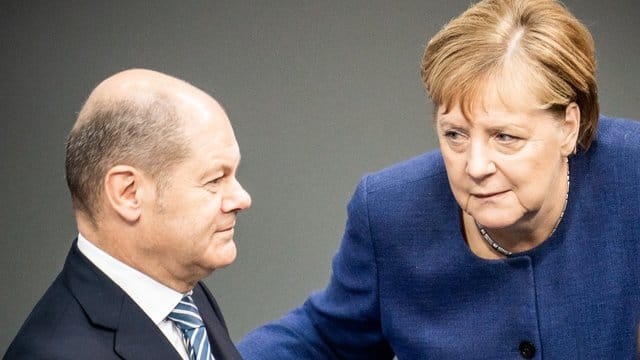 Bundeskanzlerin Angela Merkel (CDU), spricht mit Olaf Scholz (SPD), Bundesfinanzminister, im Bundestag. Bundeskanzlerin Angela Merkel (CDU), spricht mit Olaf Scholz (SPD), Bundesfinanzminister, im Bundestag.