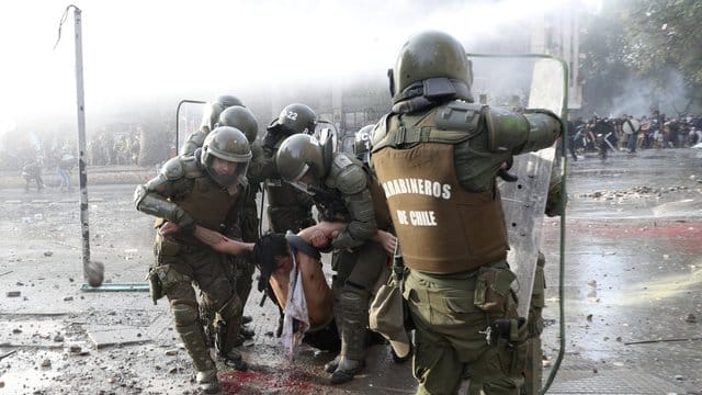 Die Polizei trägt einen regierungsfeindlichen Demonstranten, der bei Zusammenstößen verletzt wurde.