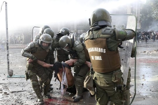 Die Polizei trägt einen regierungsfeindlichen Demonstranten, der bei Zusammenstößen verletzt wurde.