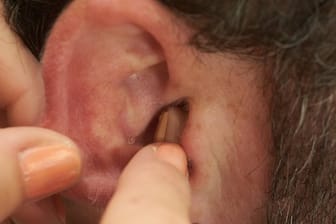 Hörgerät wird ins Ohr eingesetzt: Hängen Demenz und Schwerhörigkeit zusammen, beugt ein Hörgerät dem Gedächtnisverlust vor.