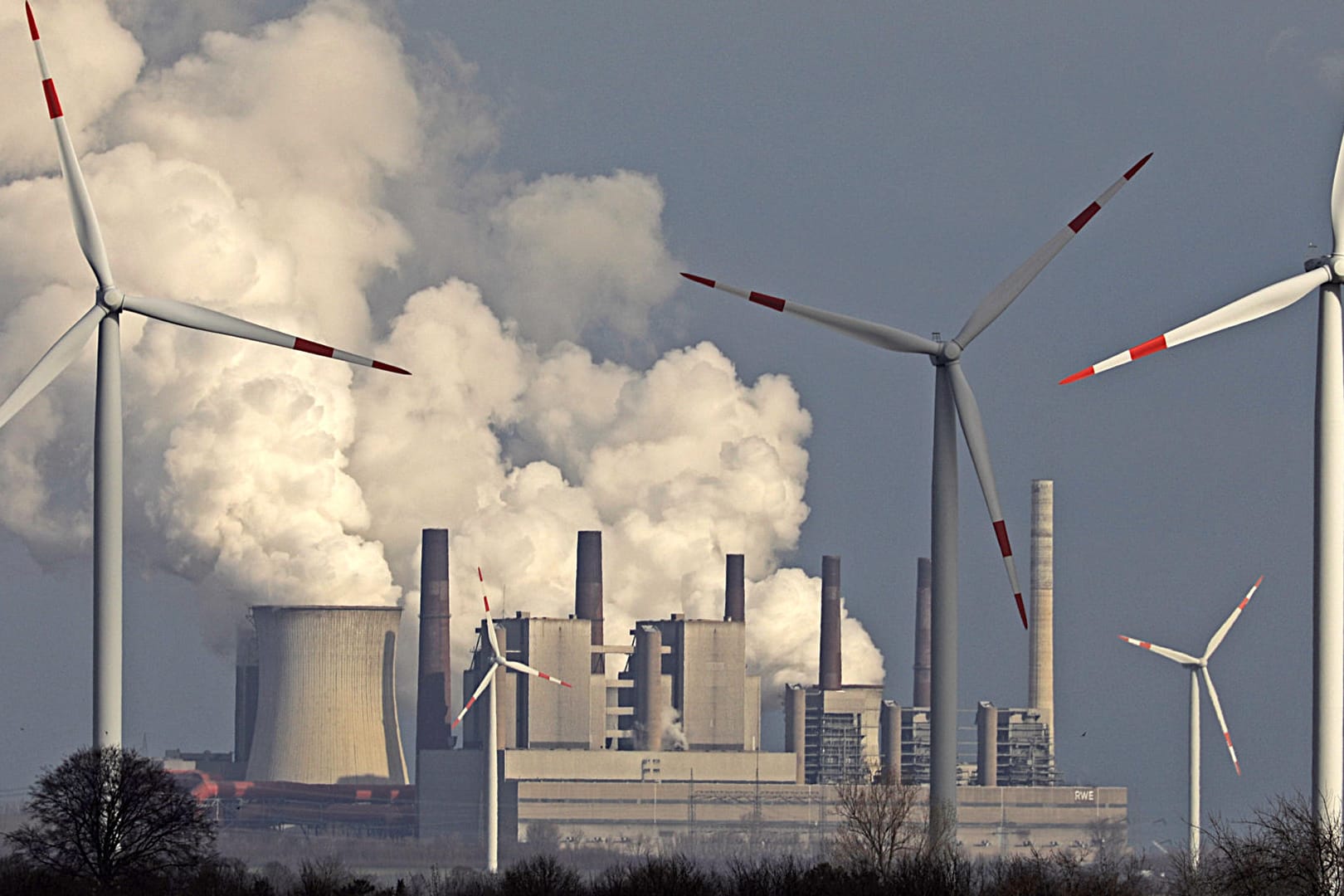 Braunkohlekraftwerk hinter Windrädern: Vor nicht einmal zwei Monaten beschlossen Klimakabinett und Spitzen von CDU, CSU und SPD die Eckpunkte des Klimaschutzprogramms 2030, das am Freitag, den 15. November 2019, durchgeboxt werden soll. (Symbolbild)