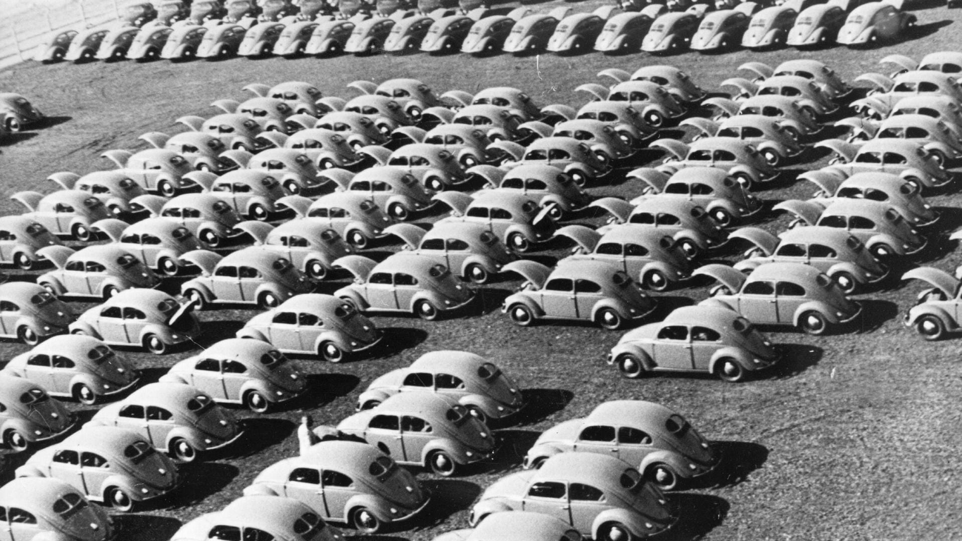 Etwa um 1950 stehen "Käfer" vor einem Werk: Die Autoindustrie wurde nach dem Zweiten Weltkrieg für Deutschland zu einer der wichtigsten Branchen.