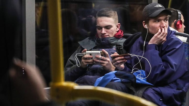 Junge Männer surfen in einem Bus (Symbolbild): Deutschland hat mit die teuersten Datentarife in Europa.