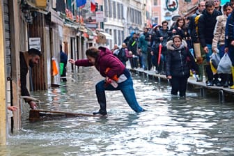 Überschwemmungen in Venedig: Eine Frau versucht, eine überflutete Straße zu überqueren.