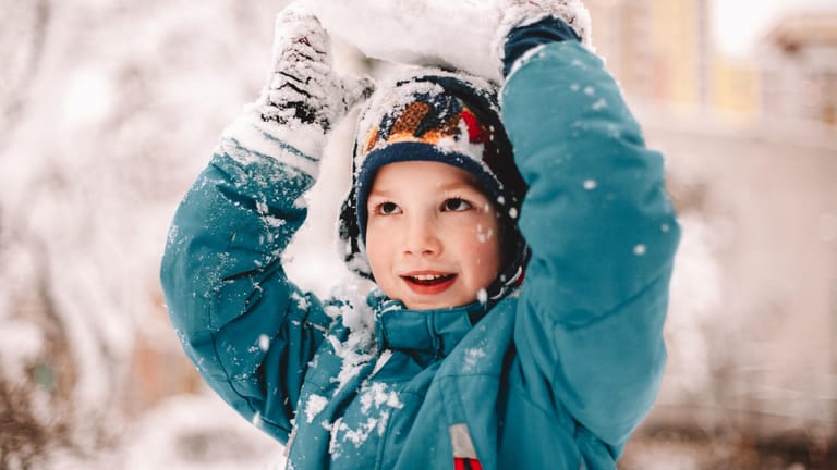 Ein Junge spielt im Schnee: Kinder scheinen weniger zu frieren, da sie sich generell mehr bewegen und die Muskelaktivität einen kleineren Körper schneller aufwärmt als einen großen.