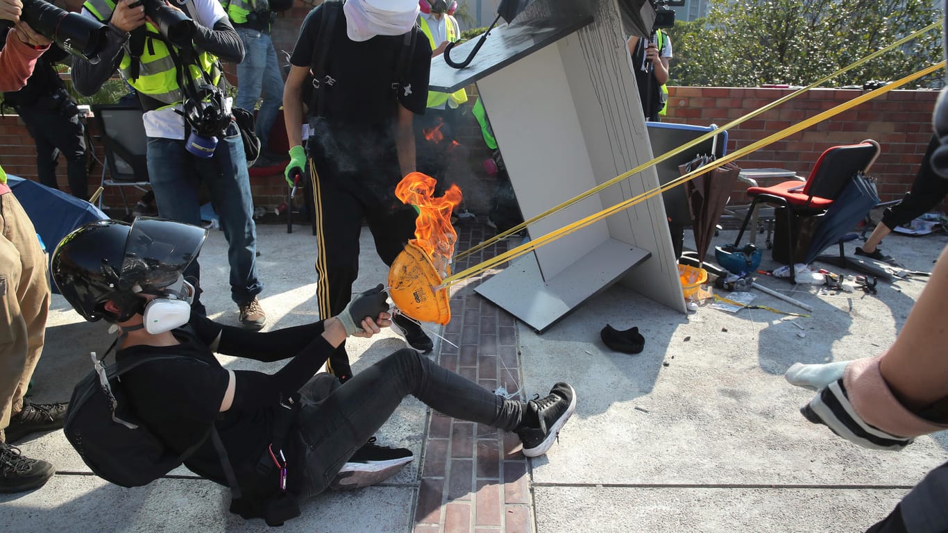 Demonstranten benutzen eine improvisierte Schleuder, um einen Molotov-Cocktail abzufeuern: Die Ausschreitungen konzentrierten sich zunächst vor allem auf die Gegend um die Polytechnische Universität.