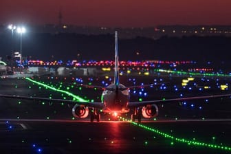 Ein Passagierflugzeug rollt im letzten Licht der untergehenden Sonne über die Rollbahn des Frankfurter Flughafens.