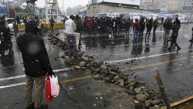 Eine Straße in Teheran wird von Demonstranten blockiert, nachdem die Behörden die Benzinpreise erhöht haben. Eine Straße in Teheran wird von Demonstranten blockiert, nachdem die Behörden die Benzinpreise erhöht haben.
