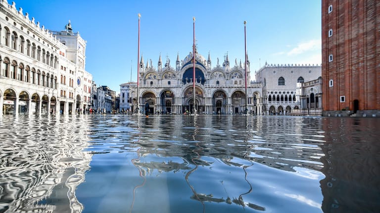 Der Dogenpalast spiegelt sich im Hochwasser auf dem Markusplatz: Nicht nur Venedig leidet in diesen Tagen unter Extremwetter.