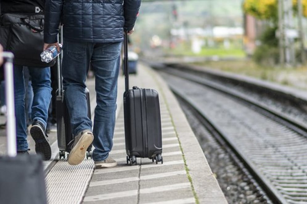 Zugreisende laufen am Bahnsteig am Hauptbahnhof.