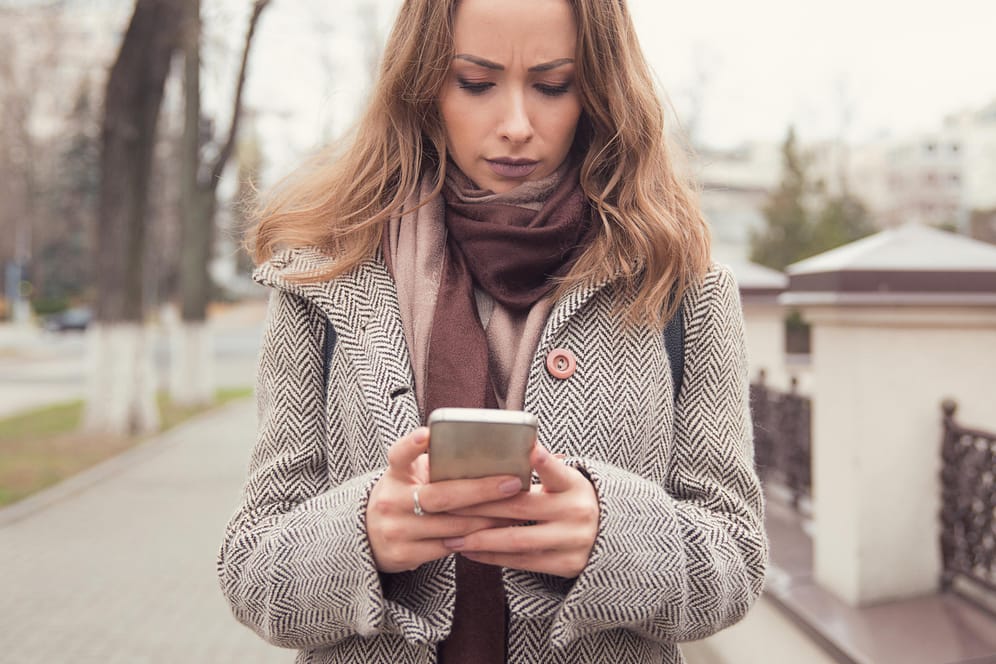 Eine Frau schaut enttäuscht auf ihr Smartphone: Der Wechsel von UMTS zum schnellen LTE-Netz vollzieht sich in Deutschland nur langsam.