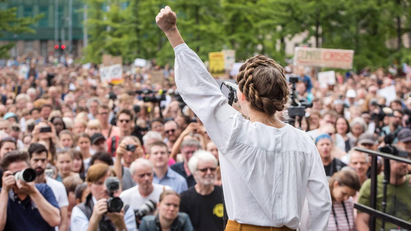 Die Aktivistin Clara Meyer hebt auf einer Demonstration in Berlin die linke Faust: Die Klimaschützer fordern, dass sich Staaten ans Pariser Abkommen halten.