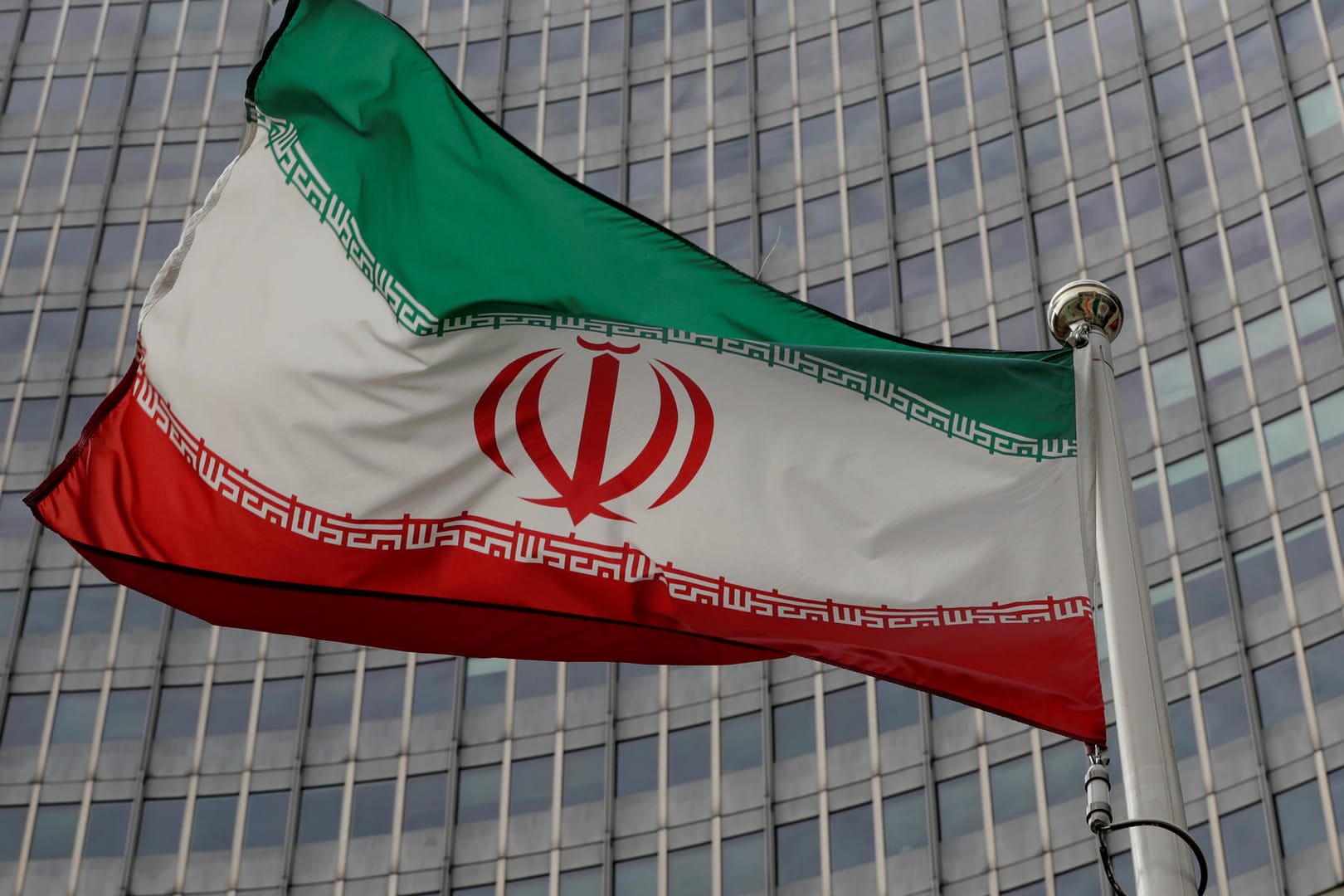 Die iranische Flagge vor dem Gebäude der IAEA in Wien: Das Land ist zwar noch Teil des Atomabkommens, verstößt aber immer wieder gegen dessen Regelungen.