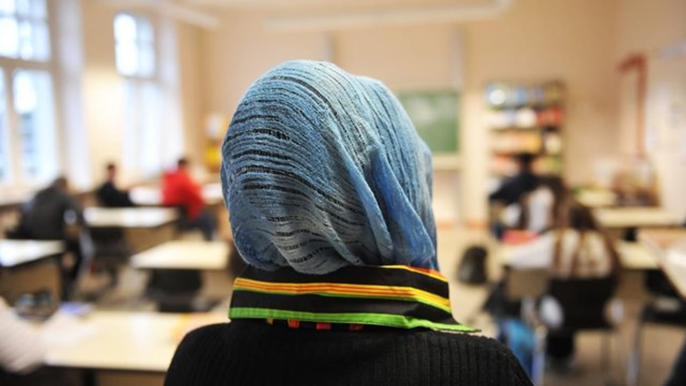 Eine Schülerin mit Kopftuch nimmt am Unterricht teil.