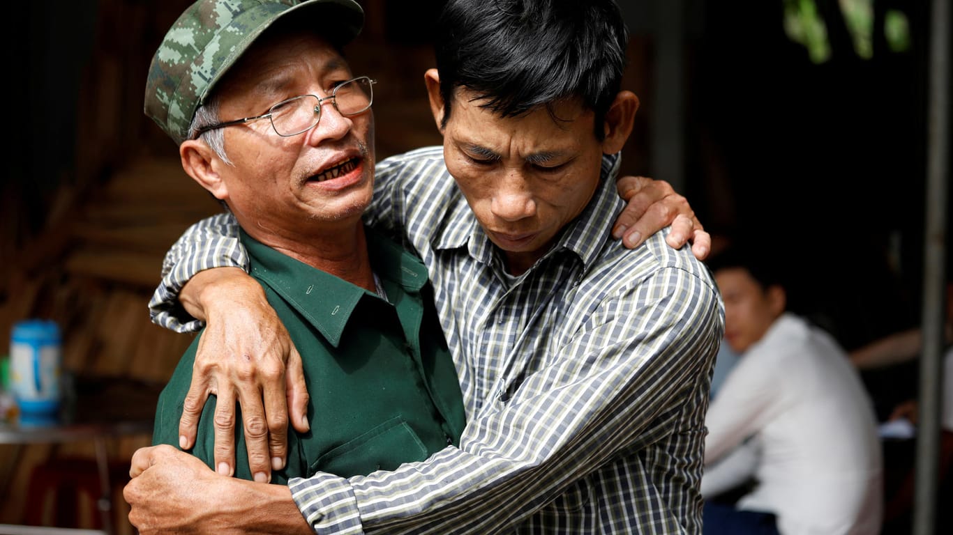Der Vater von einem der Londoner Opfer wird von einem Freund umarmt: Die Angehörigen müssen für die Überführung der Toten zurück nach Vietnam wohl selbst aufkommen.