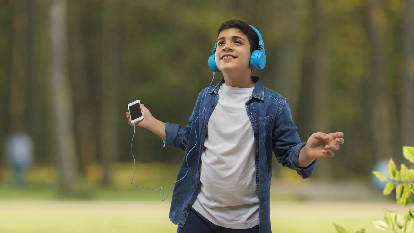 Junge mit Kopfhörern und Smartphone: Der kostenlose Musikstreamingdienst von Amazon ist ab sofort in Deutschland verfügbar.