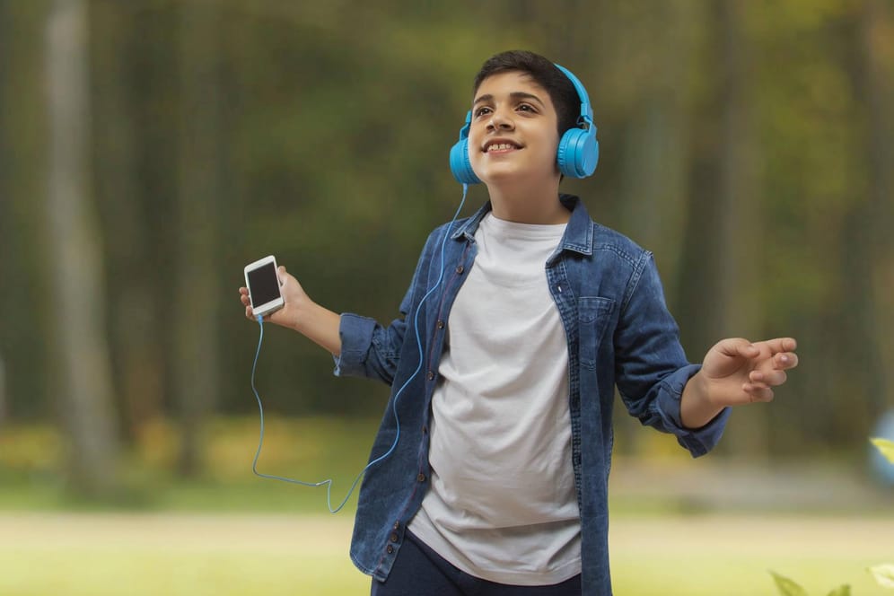 Junge mit Kopfhörern und Smartphone: Der kostenlose Musikstreamingdienst von Amazon ist ab sofort in Deutschland verfügbar.