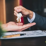 Schlüsselübergabe nach Vertragsunterzeichnung: Experten raten, mehrere Angebote für eine Immobilienfinanzierung einzuholen.