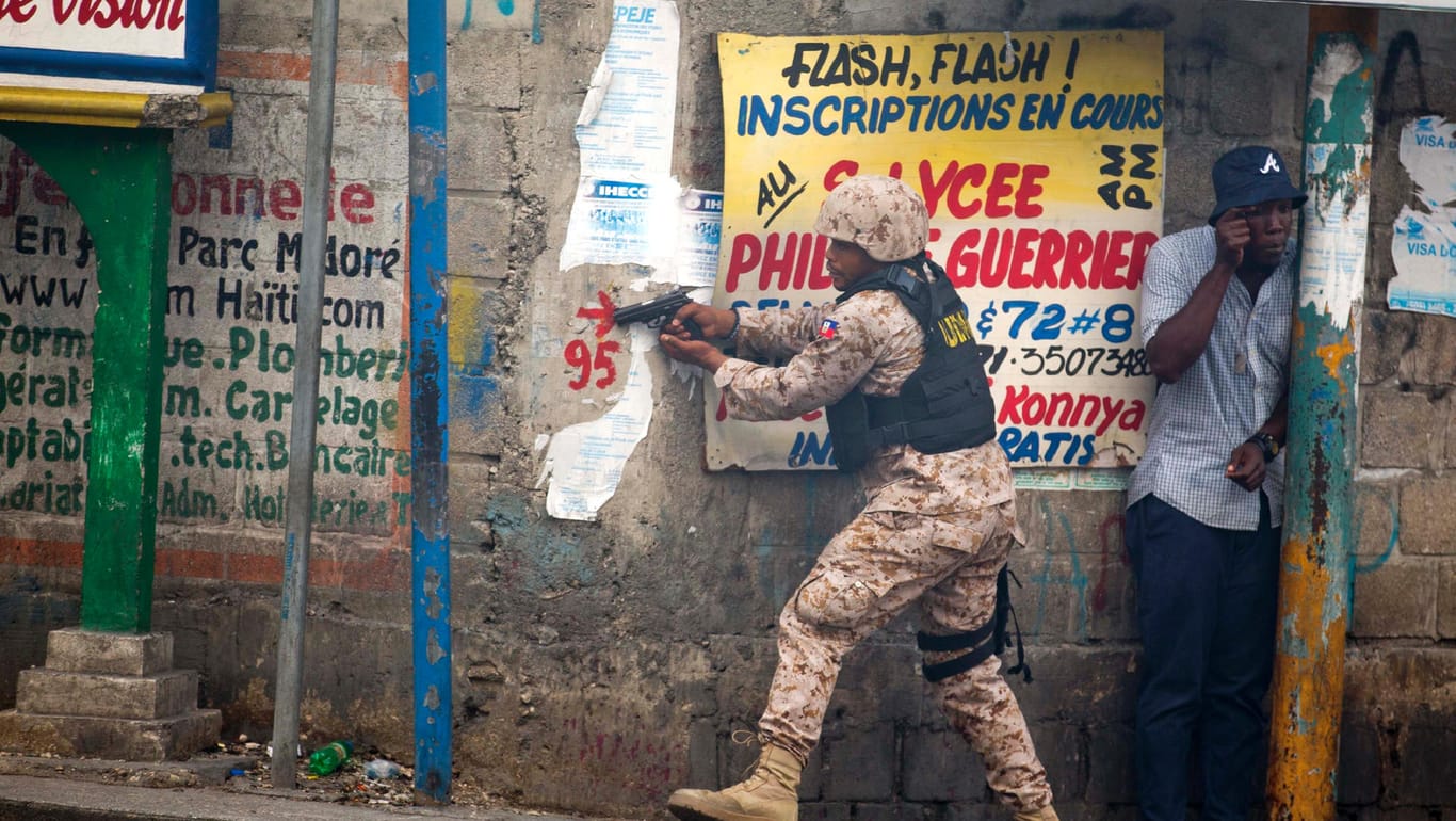 Haiti, Port-Au-Prince: Ein Polizist richtet seine Waffe auf Demonstranten, die den Rücktritt des Präsidenten Moise fordern.