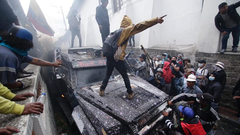 Ecuador: Anti-Regierungs-Demonstranten steigen auf ein gepanzertes Fahrzeug der Polizei.