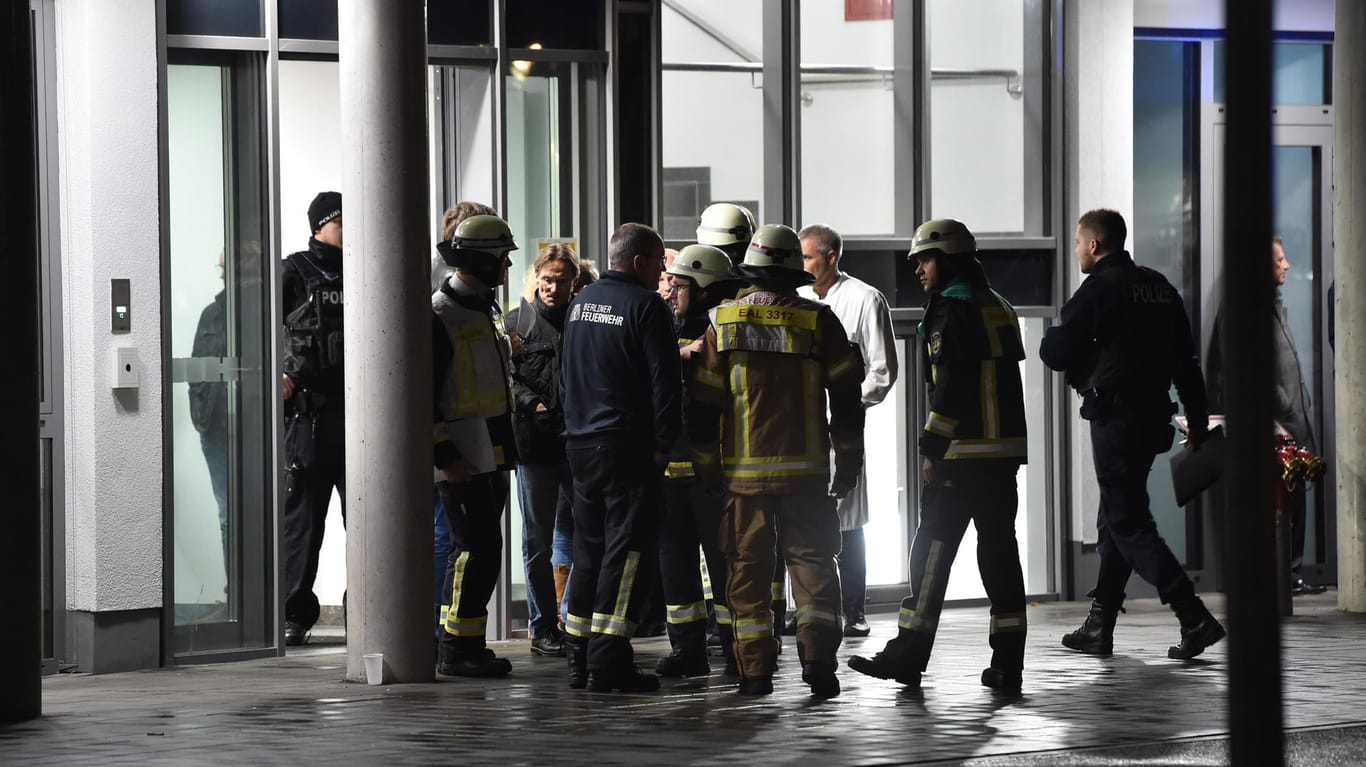 Nach der Attacke auf Fritz von Weizsäcker: Feuerwehrleute, Polizisten und medizinisches Personal stehen nach dem Angriff vor der Schlosspark-Klinik in Berlin.