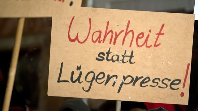 Pegida-Anhänger halten ein Schild mit der Aufschrift "Wahrheit statt Lügenpresse!" hoch. Pegida-Anhänger halten ein Schild mit der Aufschrift "Wahrheit statt Lügenpresse!" hoch.