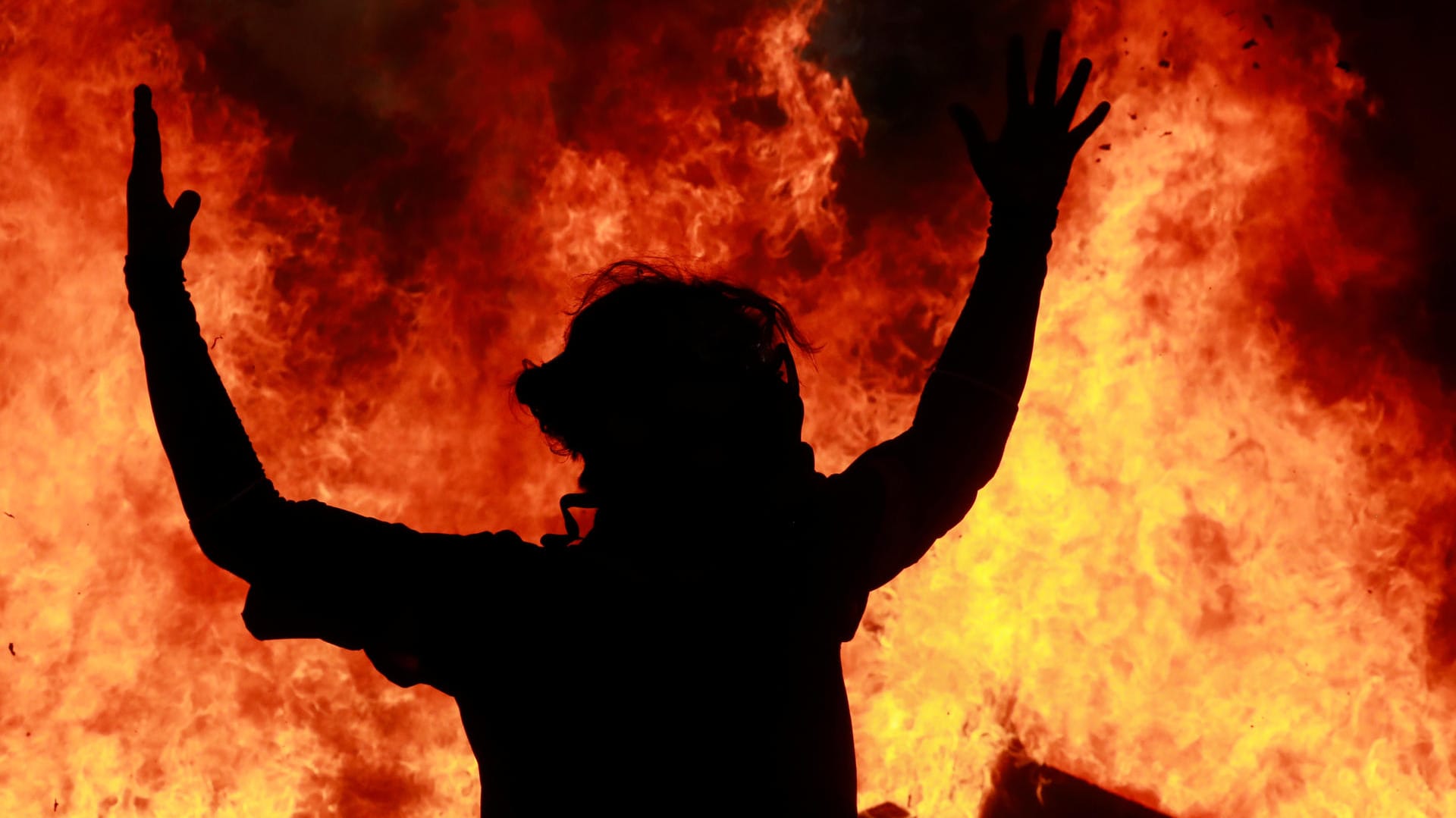 Ein Demonstrant gestikuliert vor einem Feuer in Santiago de Chile: In vielen Staaten protestieren Tausende. Was bedeutet das?