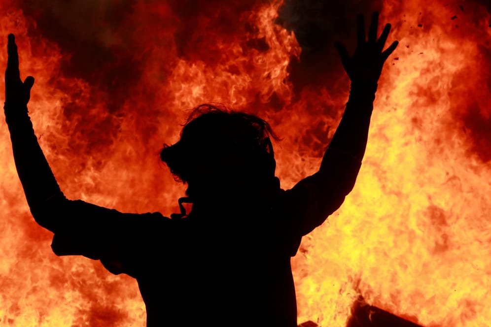 Ein Demonstrant gestikuliert vor einem Feuer in Santiago de Chile: In vielen Staaten protestieren Tausende. Was bedeutet das?