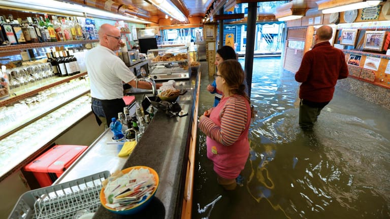 Ein Cafe im überschwemmten Venedig: Die Schäden durch die Klimakrise sind vielfältig.