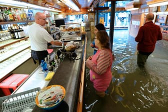Ein Cafe im überschwemmten Venedig: Die Schäden durch die Klimakrise sind vielfältig.