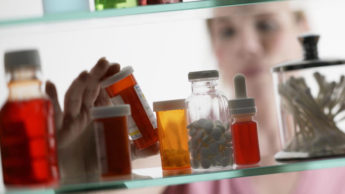 Eine Frau nimmt ein Medikament aus der Hausapotheke: Mittel gegen Schmerzen sollte jeder für den Notfall zu Hause haben.