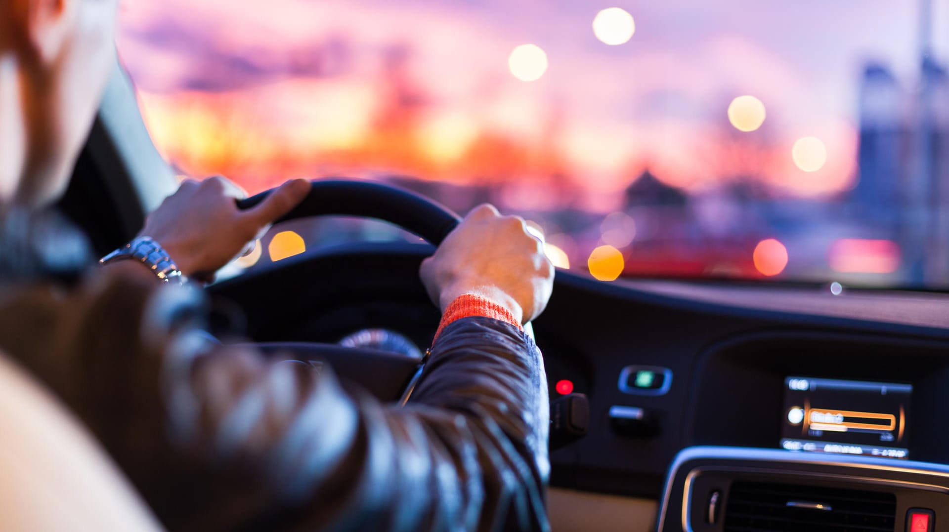 Ein Mann fährt Auto: Einer Befragung zufolge sind Autofahrer häufig durch ihr Handy oder Hörbücher abgelenkt.