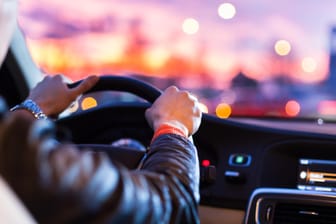Ein Mann fährt Auto: Einer Befragung zufolge sind Autofahrer häufig durch ihr Handy oder Hörbücher abgelenkt.