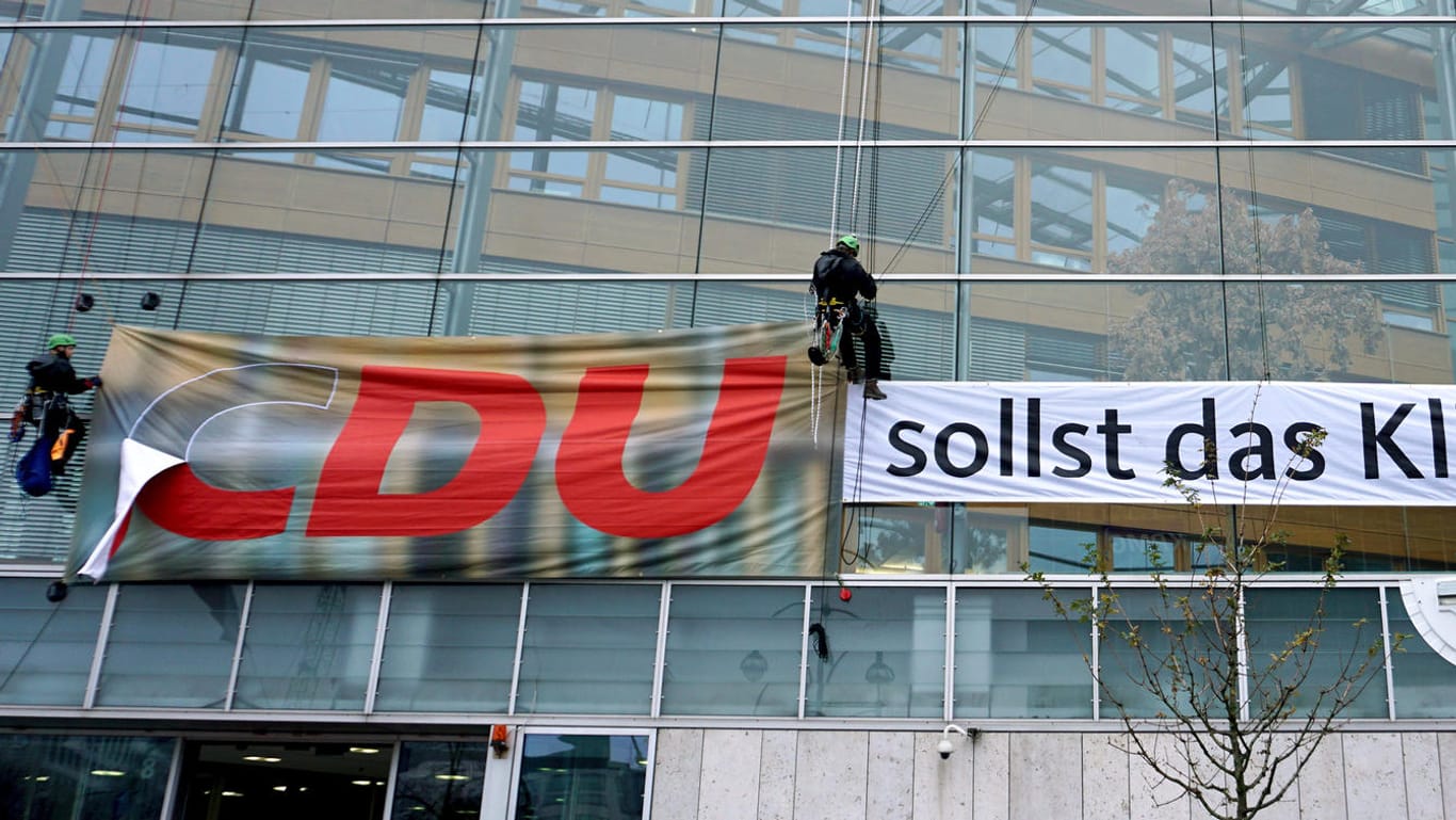 Berlin: Greenpeace-Aktivisten hängen ein Plakat an der CDU-Zentrale auf.
