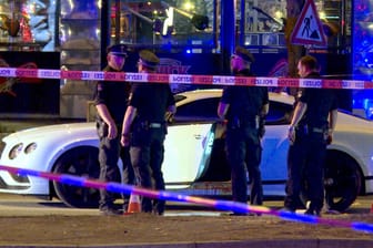 Polizisten stehen neben einem Auto an der Reeperbahn: Mehr als ein Jahr nach den beinahe tödlichen Schüssen auf einen Rockerboss in Hamburg ist nun der Vater des mutmaßlichen Auftraggebers festgenommen worden.