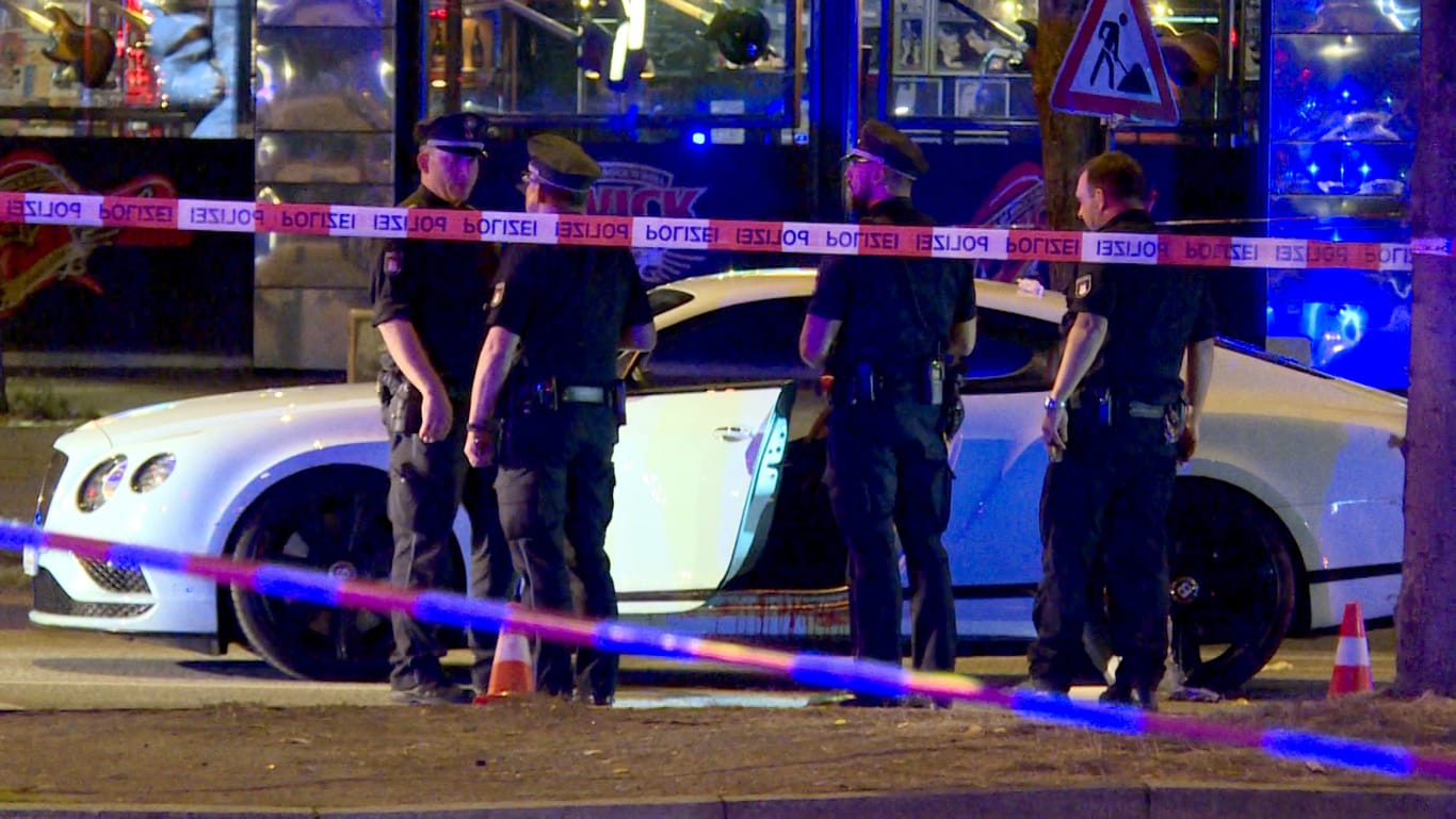 Polizisten stehen neben einem Auto an der Reeperbahn: Mehr als ein Jahr nach den beinahe tödlichen Schüssen auf einen Rockerboss in Hamburg ist nun der Vater des mutmaßlichen Auftraggebers festgenommen worden.