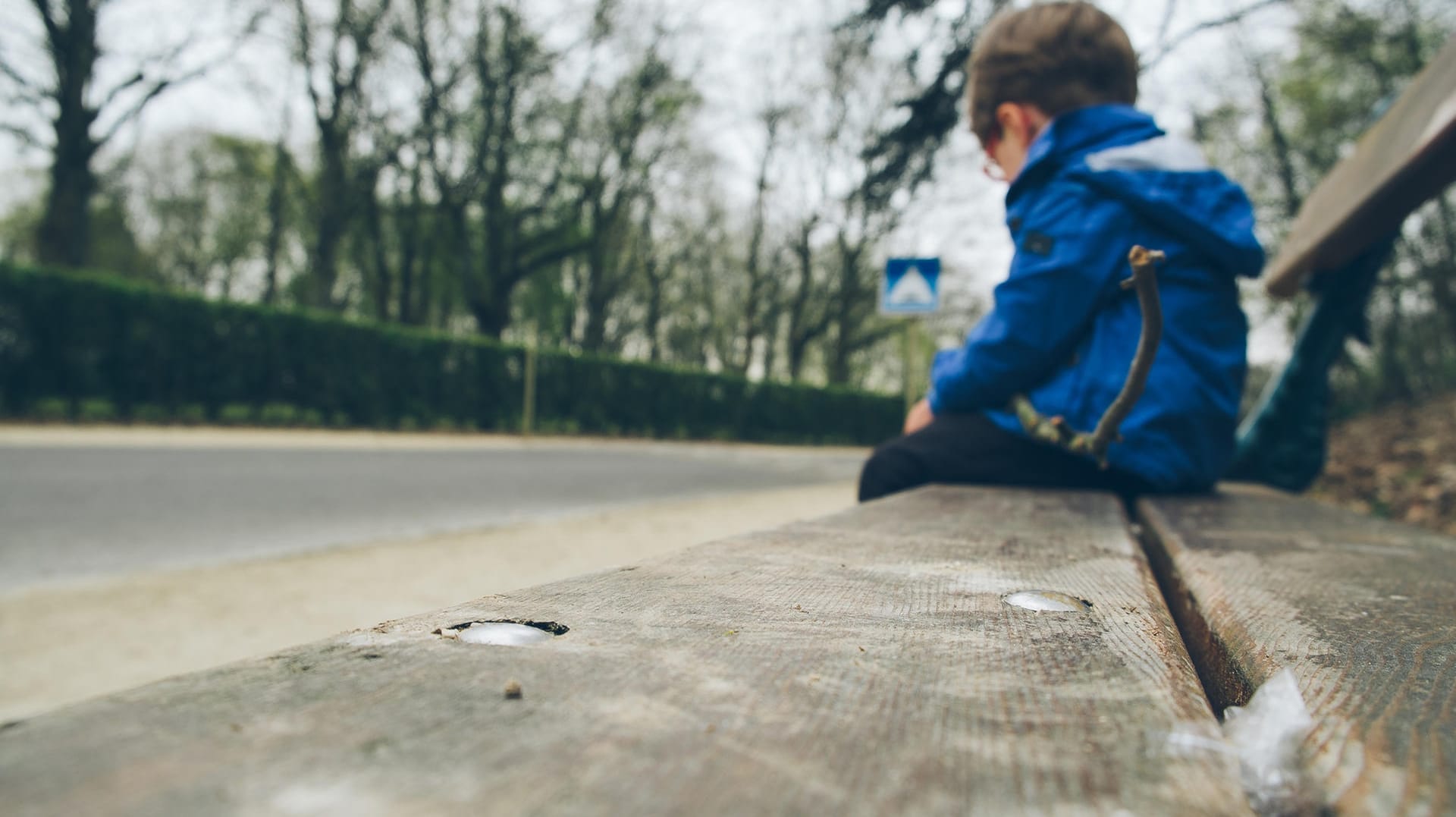 Ein trauriger Junge sitzt auf einer Bank: Wenn Empfänger von Hartz IV gegen Auflagen verstoßen, kann das eine Sanktionierung zur Folge haben. Die trifft auch Kinder.