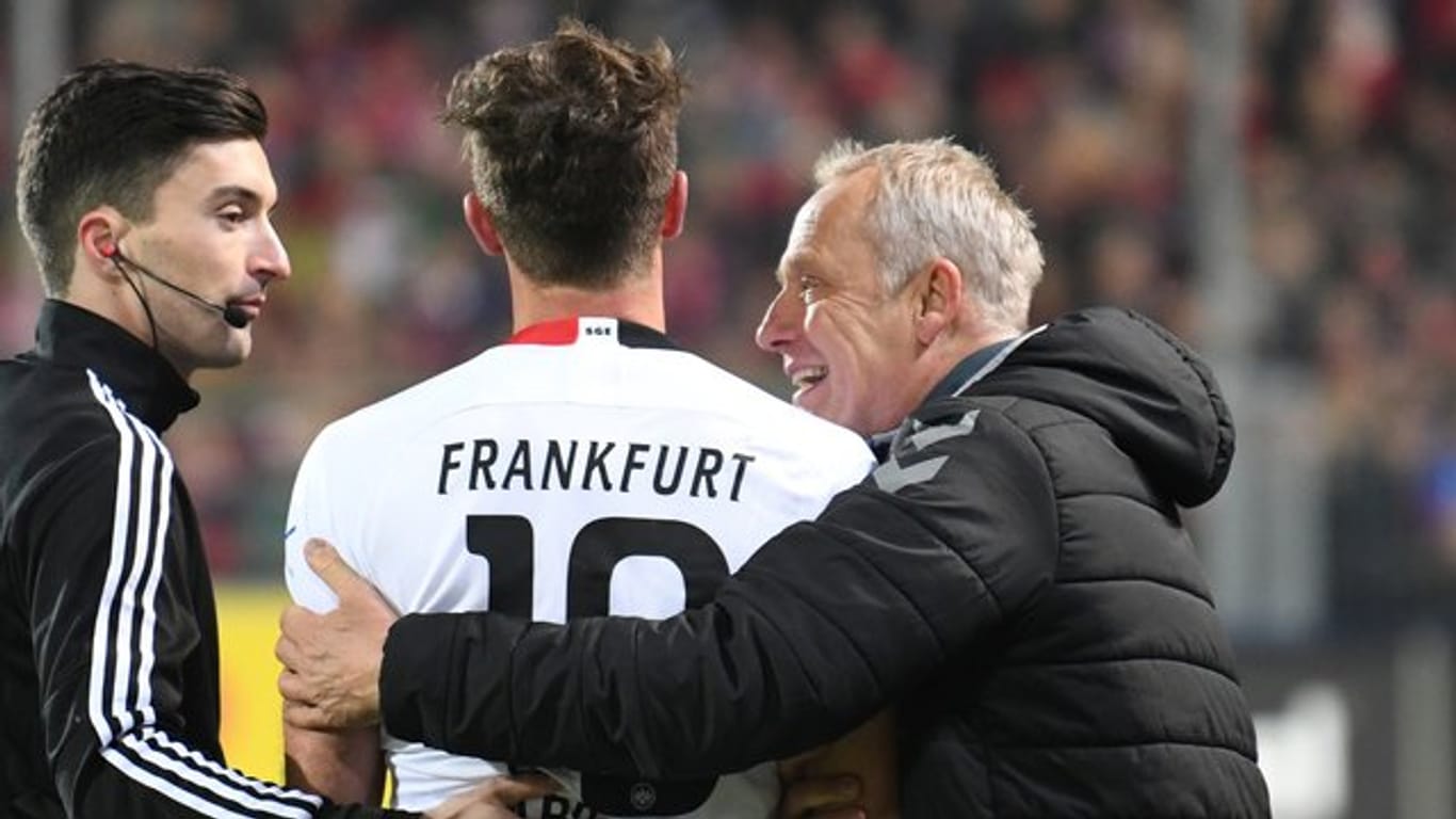 Freiburgs Trainer Christian Streich (r) umarmt Frankfurts David Abraham (l).