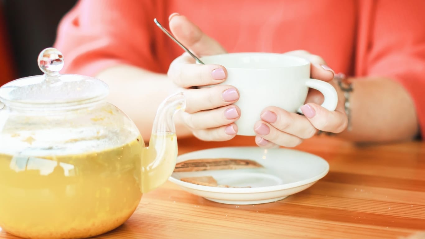 Eine Frau hält eine Tasse in der Hand: Tees sollen helfen, die Atemwege zu befreien – doch sind sie auch gesund?