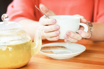 Eine Frau hält eine Tasse in der Hand: Tees sollen helfen, die Atemwege zu befreien – doch sind sie auch gesund?