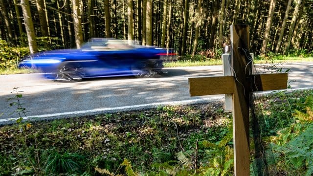 Ein Holzkreuz steht bei Achslach an der Stelle, an der die Männer bei einem Rennen den Tod eines weiteren Autofahrers verursacht haben sollen.